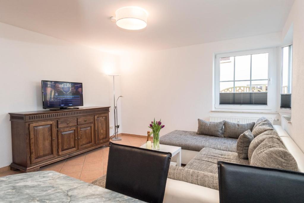 ein Wohnzimmer mit einem Sofa und einem TV in der Unterkunft Villa Mona Lisa Whg. 6 in Göhren