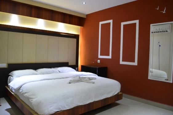 a bedroom with a large bed with white sheets at Star MSR Residency in Perambalūr