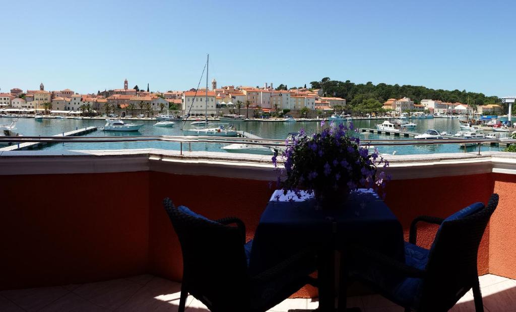 a table on a balcony with a view of a marina at Vila "Mare" in Rab