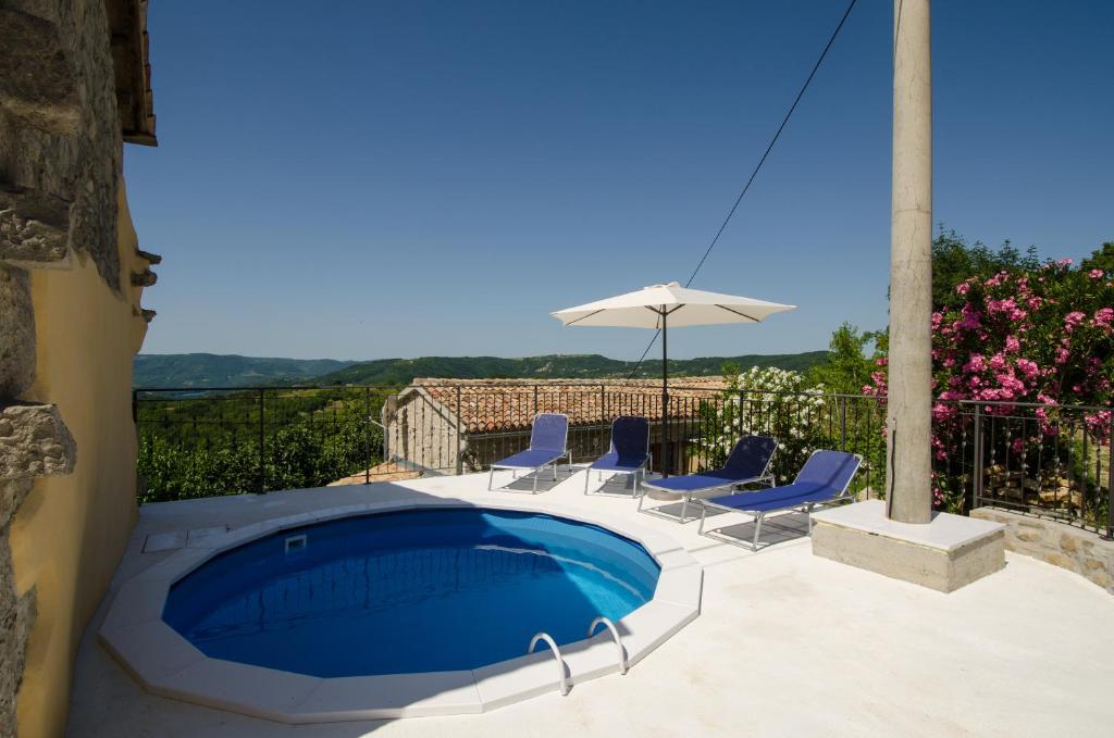 einen Pool mit Stühlen und einem Sonnenschirm in der Unterkunft Residence Hidden Heaven in Buzet
