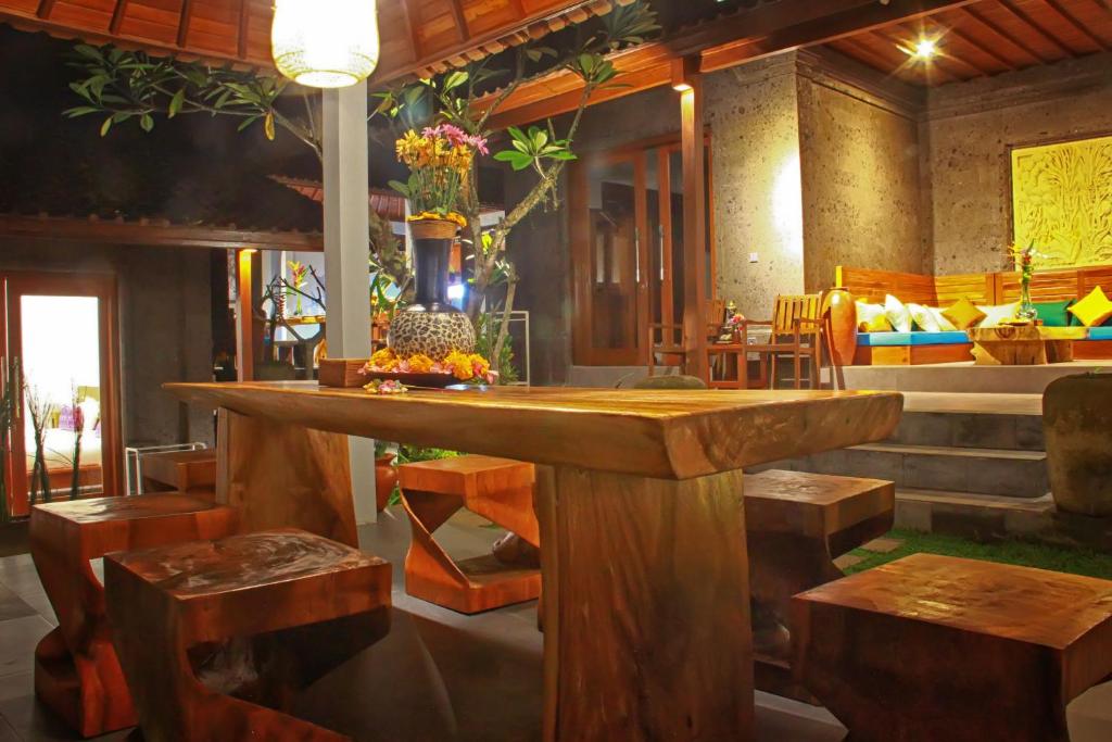 a room with a large wooden table and benches at Villa Kicen Ubud in Ubud