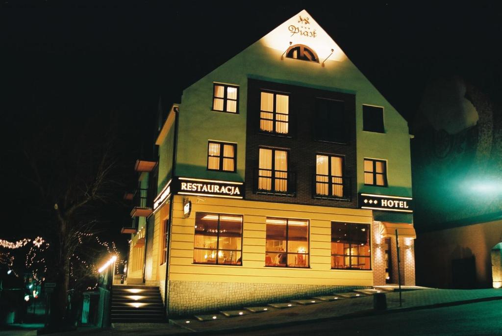 un edificio de noche con sus luces encendidas en Hotel Piast, en Cedynia