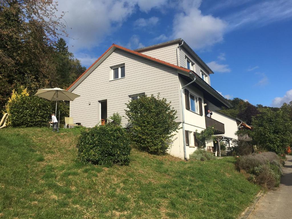 una casa blanca con un paraguas en una colina en Alpenpanorama am Hochrhein, en Gailingen