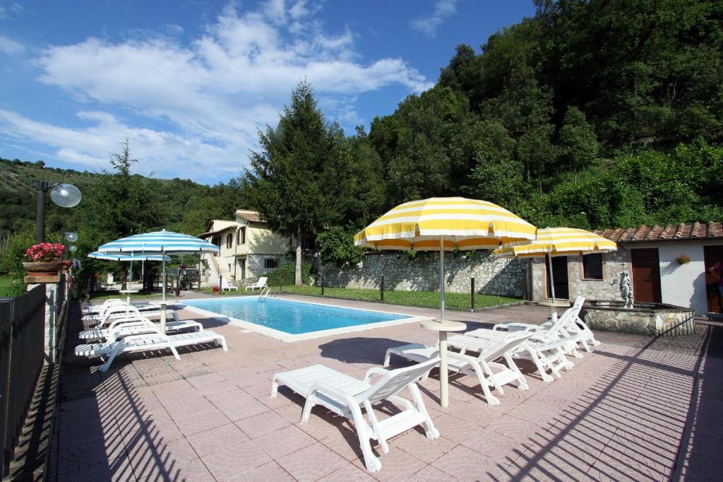 a swimming pool with chairs and umbrellas and a swimming poolvisor at Il Nasciolo in Arrone