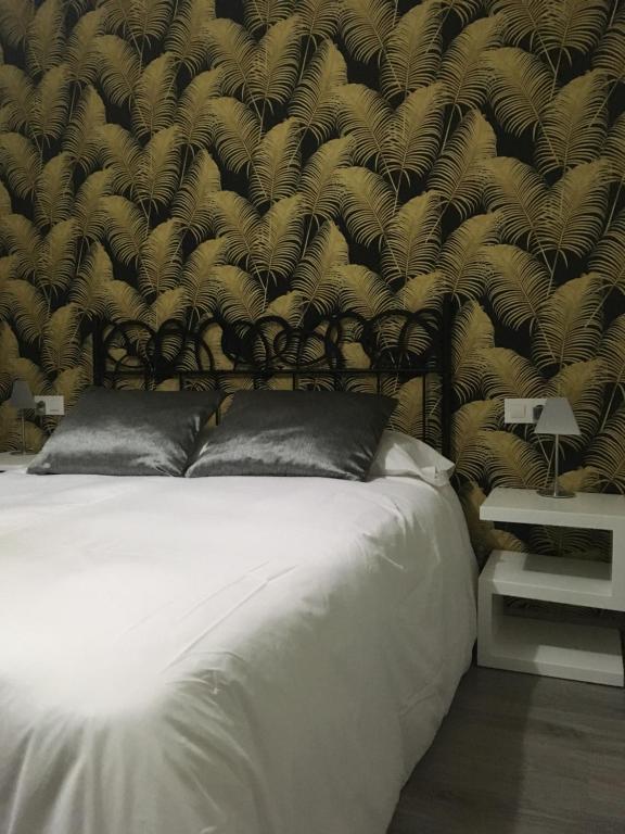una camera da letto con un grande letto bianco con un muro di Apartamentos San Gregorio ad Alquézar