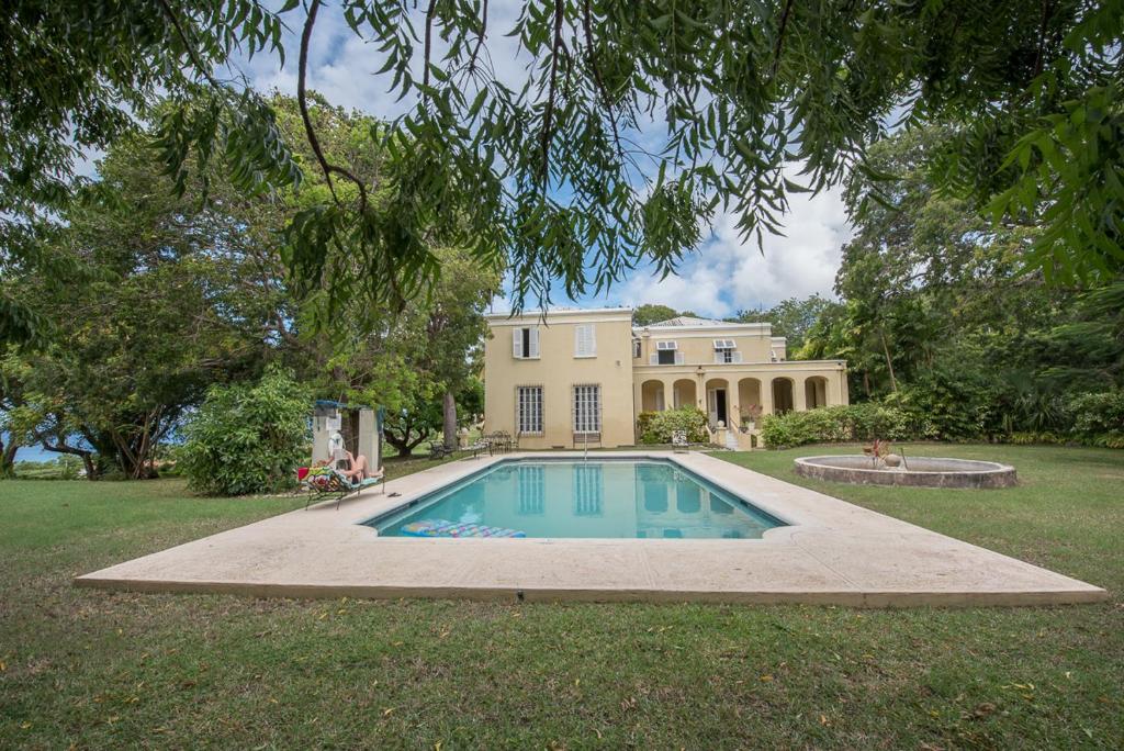 une grande maison avec une piscine dans la cour dans l'établissement Colleton Great House, à Saint Peter