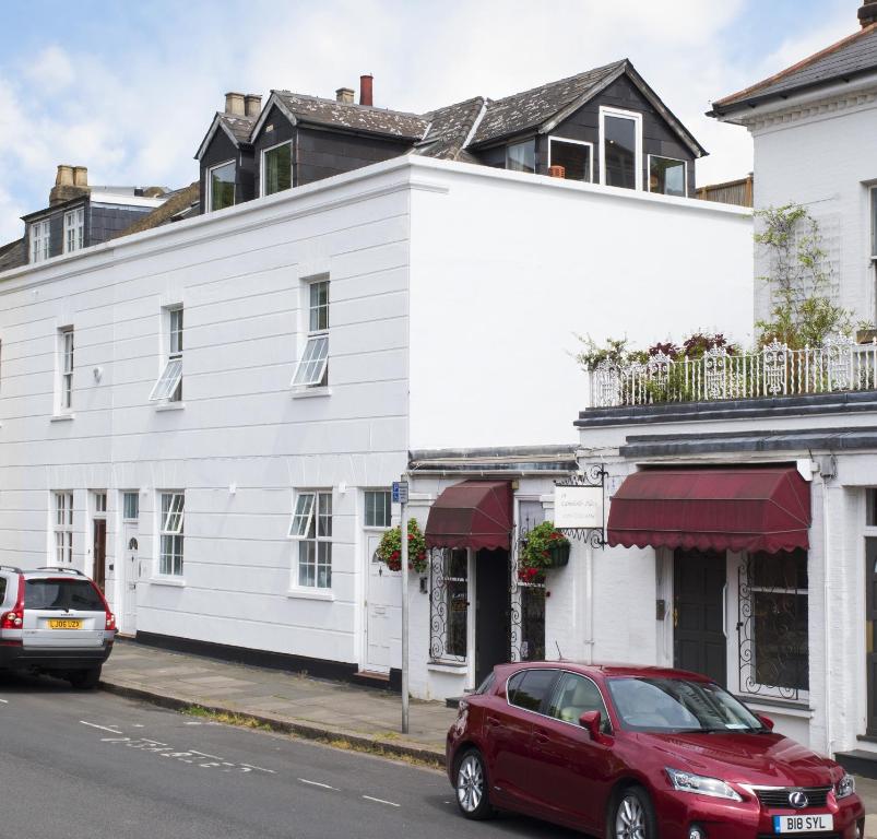 un coche rojo estacionado frente a un edificio blanco en Great Loft & Location by Belsize Park tube, en Londres