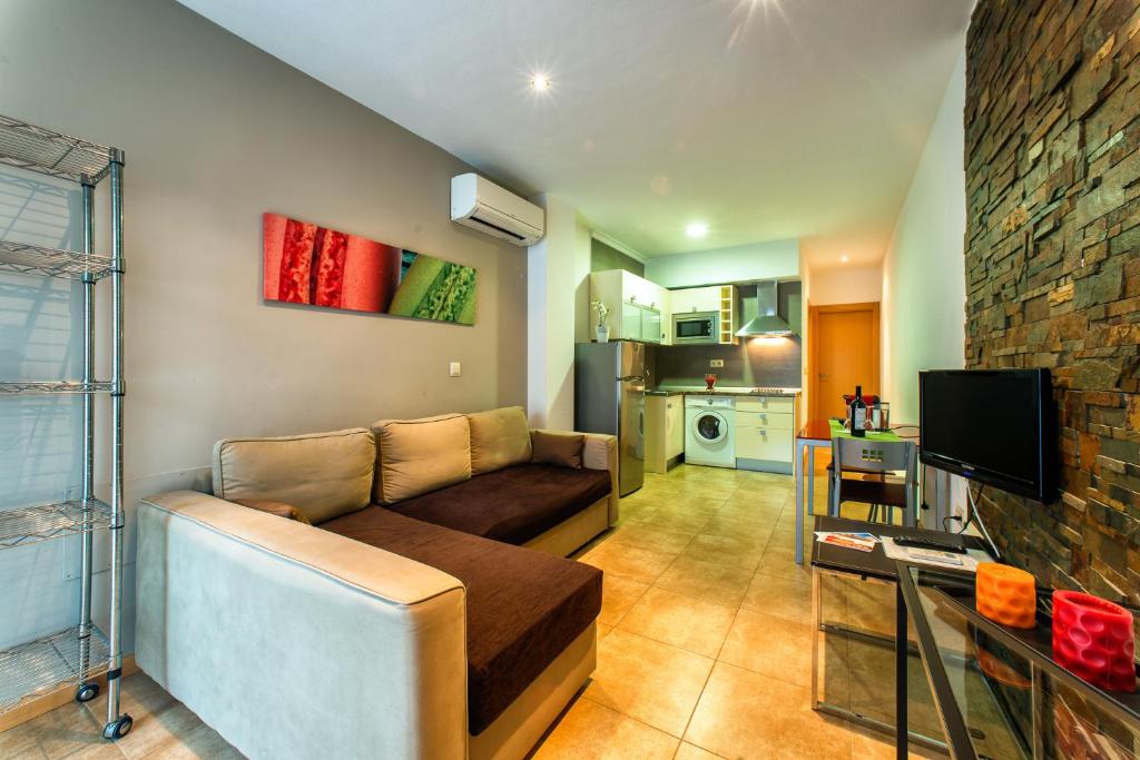 a living room with a couch and a kitchen at Apartamentos Amanecer JC1 in Murcia