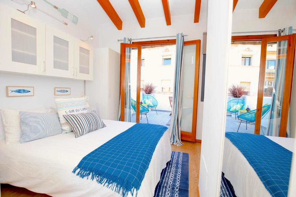 a bedroom with a bed and a balcony with chairs at Sant Miquel Homes - Turismo de interior in Palma de Mallorca