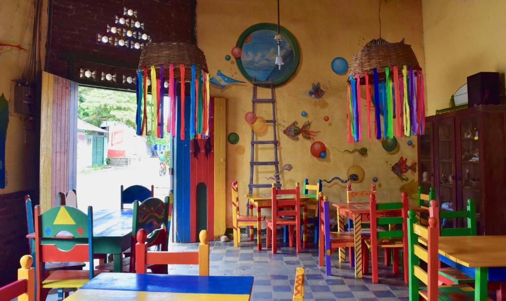 a restaurant with colorful tables and chairs in a room at Hospedaje Central in Moyogalpa