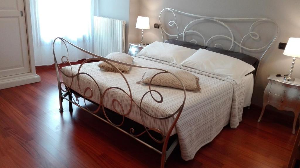 een slaapkamer met een wit bed met een metalen frame bij Camera Con Vista Este in Este