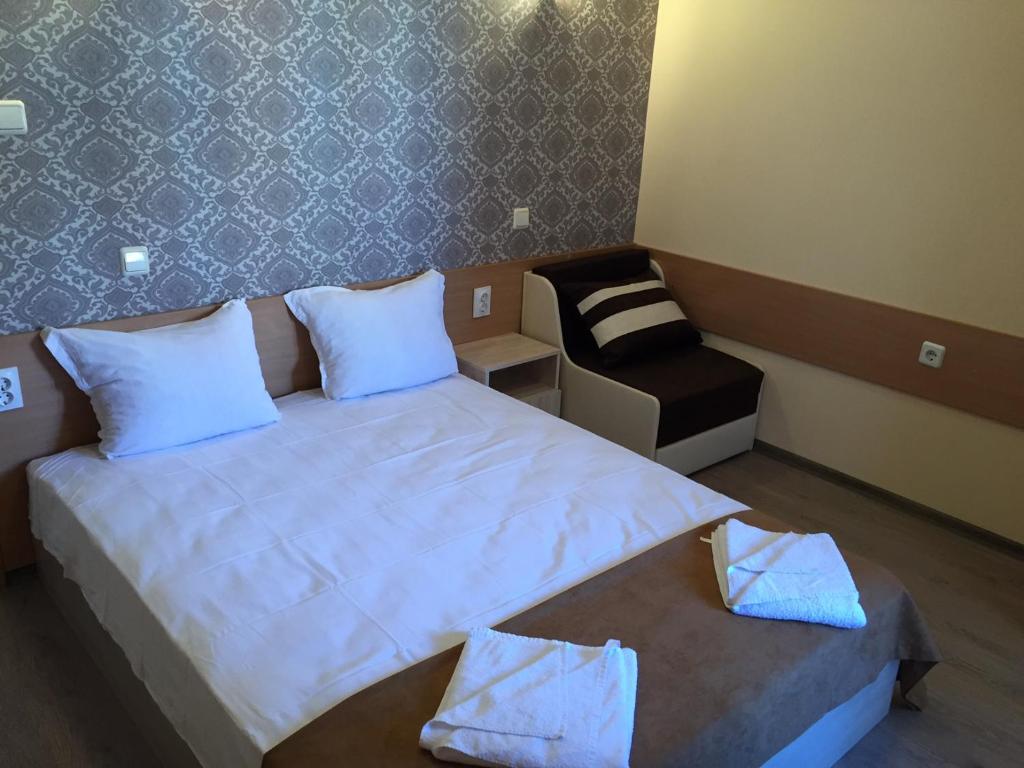 a small bedroom with a bed and a chair at Guest House Afrodita in Chernomorets