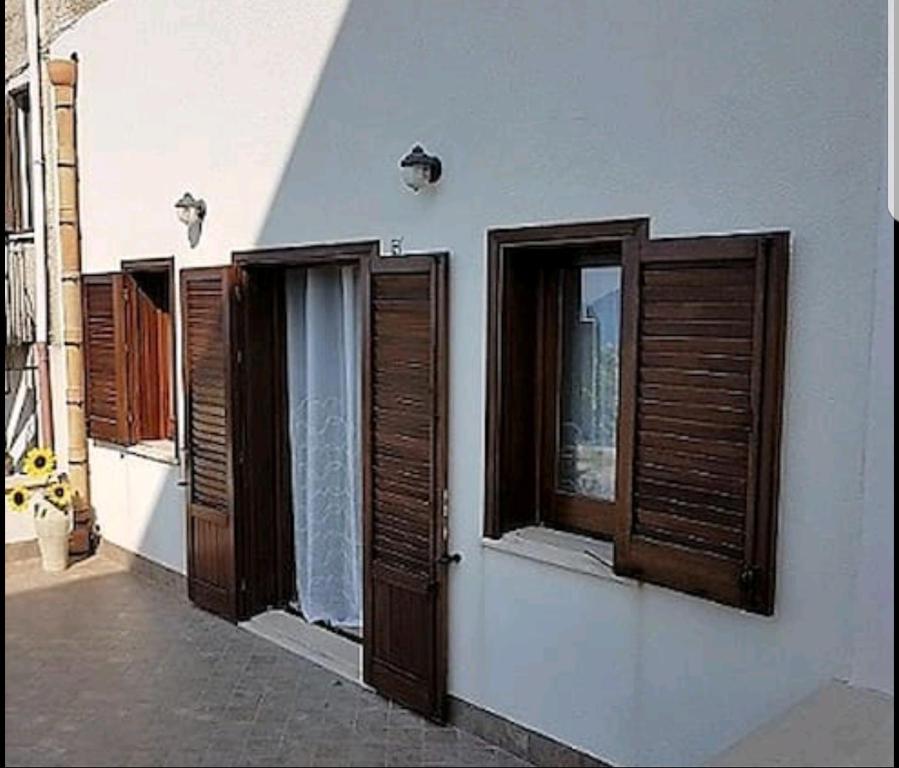 a row of windows with wooden shutters on a building at Casa Vacanza Brigida in Scopello