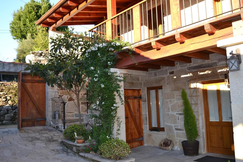 een huis met een houten deur en een veranda bij Casa Brues in Boborás