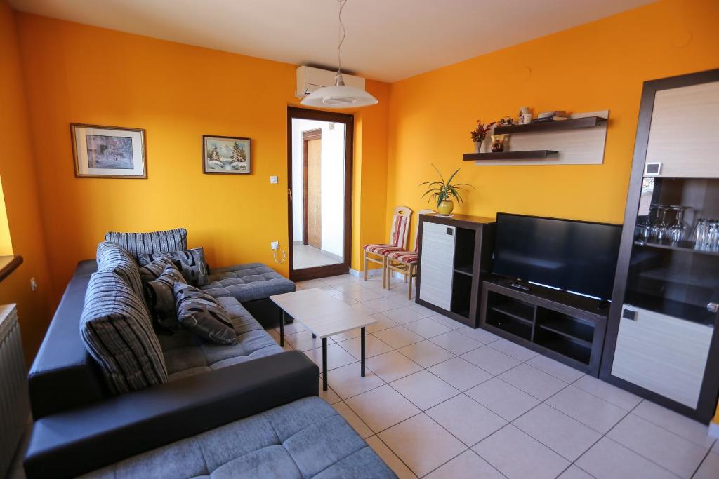 a living room with a couch and a flat screen tv at Apartment Sunny Place in Pula