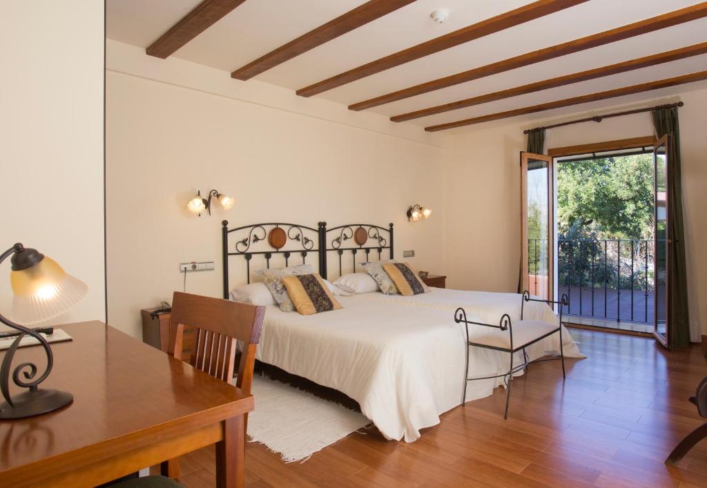 a bedroom with a bed and a table and a desk at Hotel Tossal d'Altea in Altea