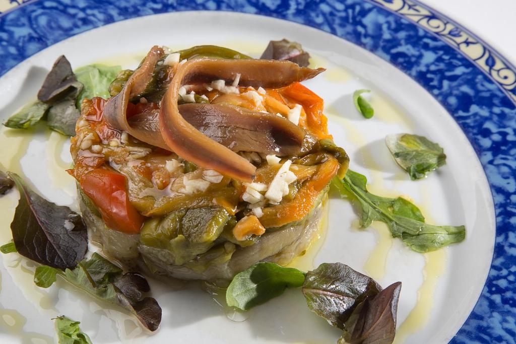 a plate of food with vegetables on a plate at Hotel Tossal d'Altea in Altea