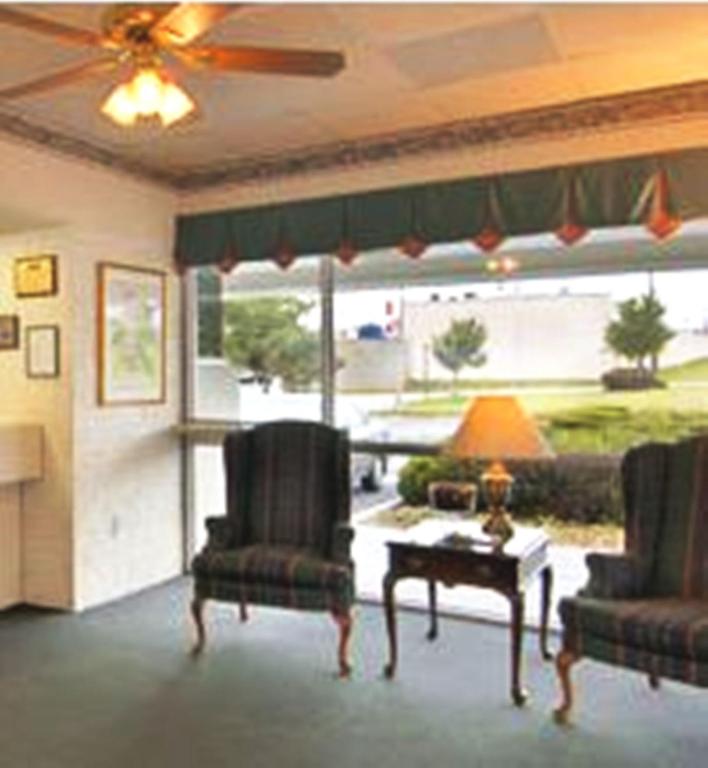 a living room with two chairs and a table at Howard Johnson by Wyndham Commerce GA in Commerce