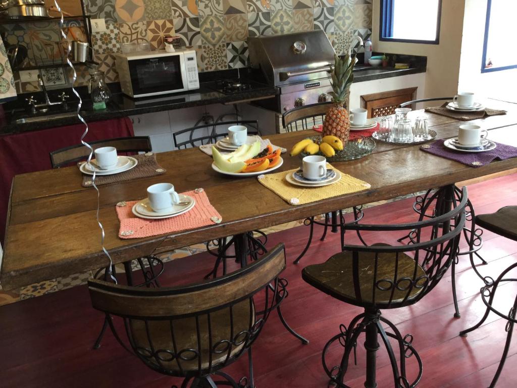 una mesa de madera con platos de comida. en Viva Chico Rei Hostel, en Ouro Preto