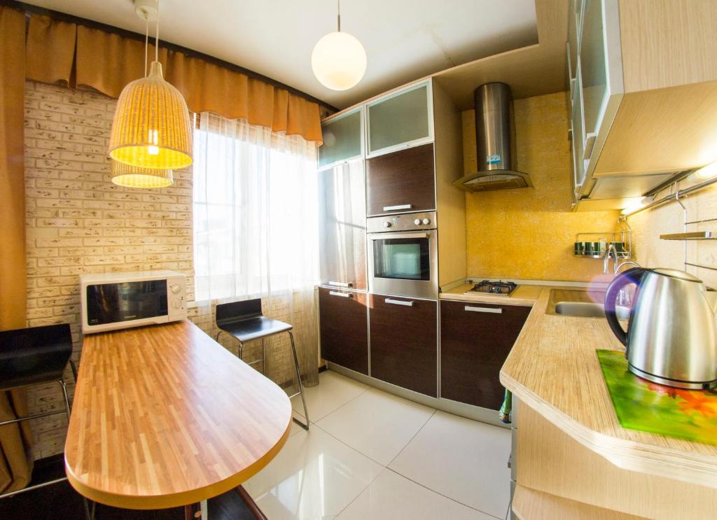 オムスクにあるRENT-сервис Apartment Sportivniy proezd 2のキッチン(木製テーブル付)