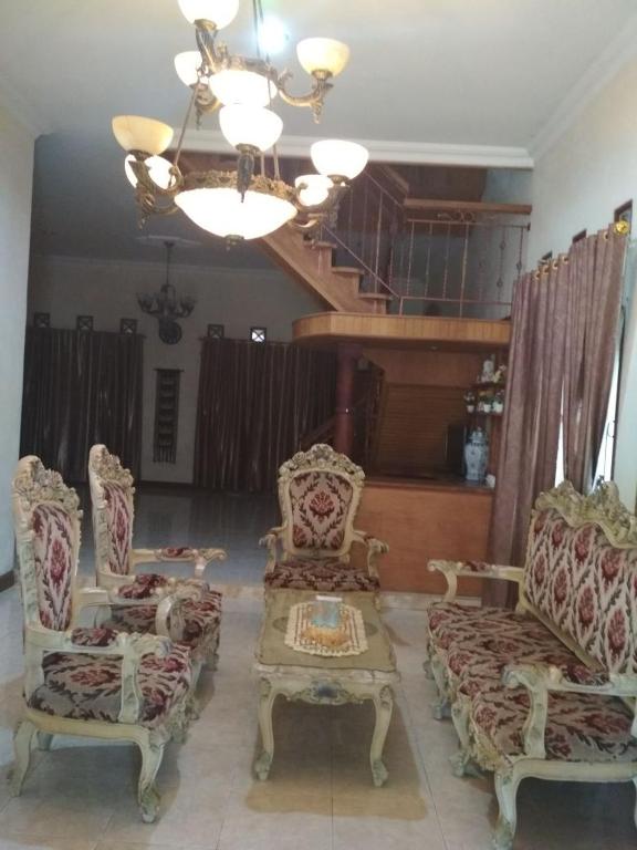 a living room with two chairs and a table and a chandelier at Rumah Puan Homestay in Bandar Lampung