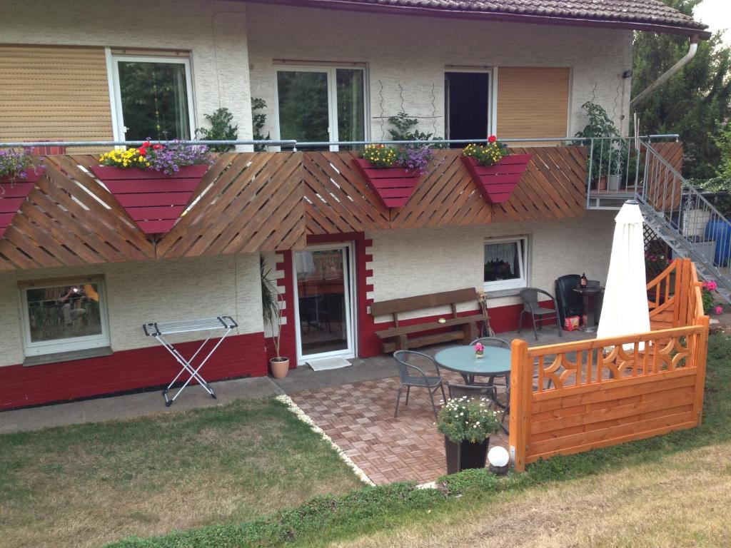 a house with a deck with a table and a patio at Ferienwohnung Caroline in Hemfurth-Edersee