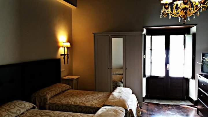 A bed or beds in a room at Hotel Rural Palacio de Galceran