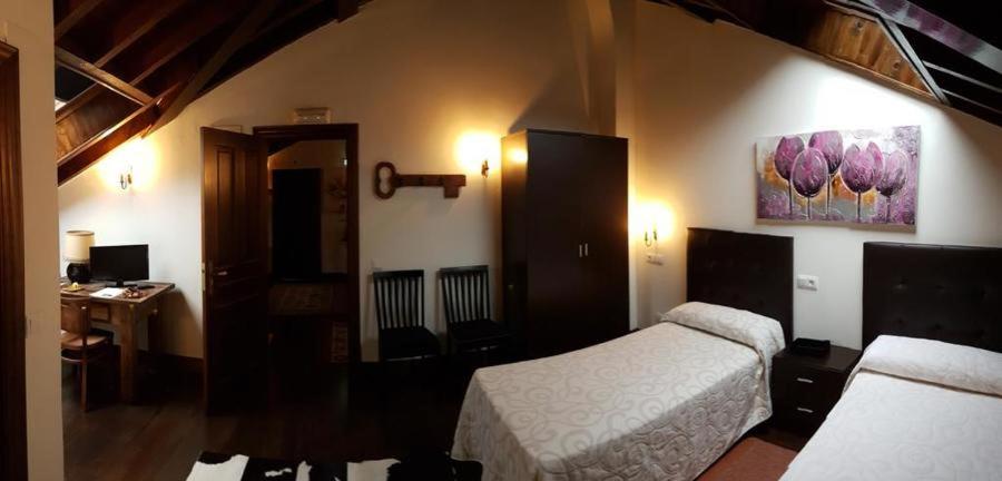 A bed or beds in a room at Hotel Rural Palacio de Galceran