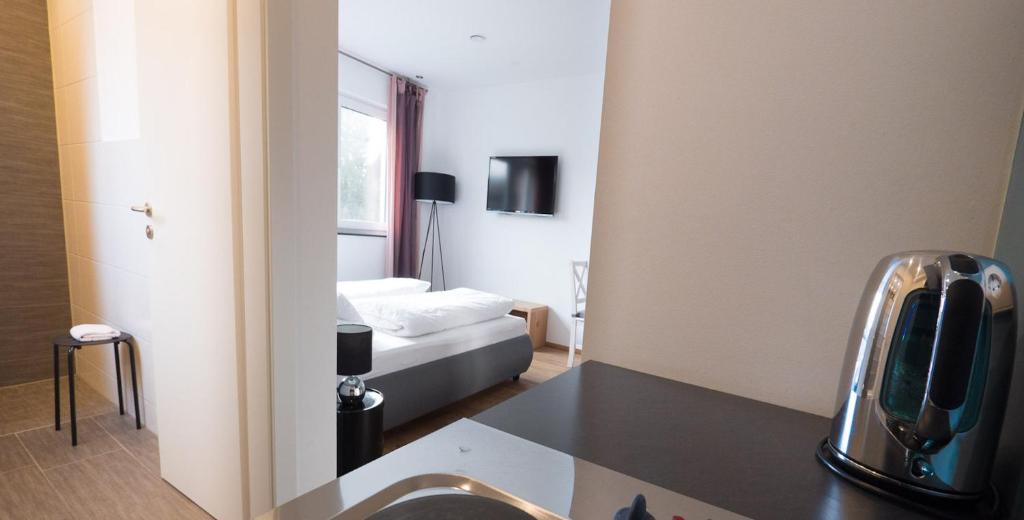 リンダウにあるFreches Wohnen - Apartmentのベッド、洗面台、鏡が備わる客室です。