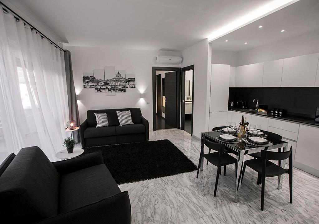 ローマにあるCasa Malupa Luxury Apartmentsのリビングルーム(黒いソファ、テーブル付)