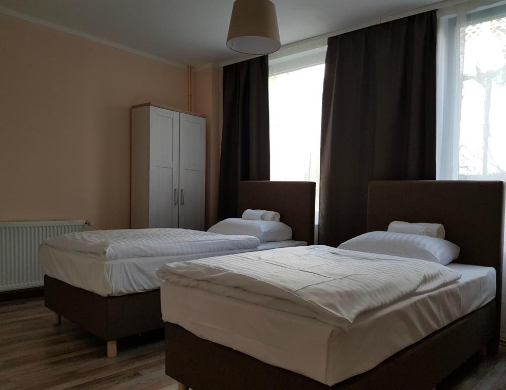 two beds in a hotel room with windows at Hotel-Residenz Oberurseler Hof in Oberursel
