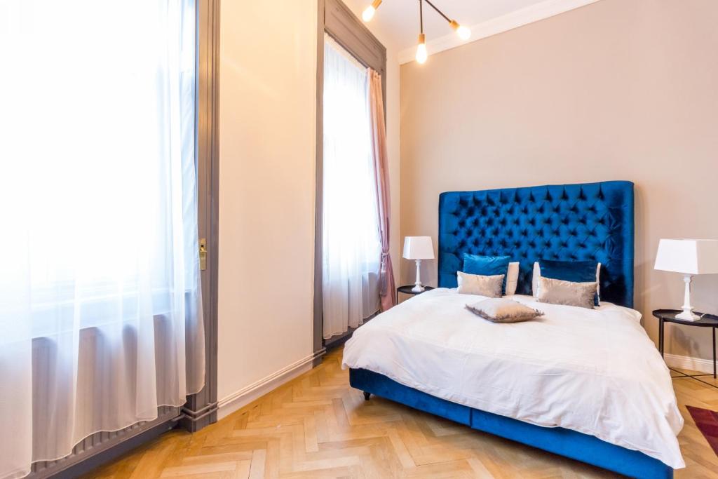 1 dormitorio con 1 cama grande y cabecero azul en Köte Haus, en Cluj-Napoca