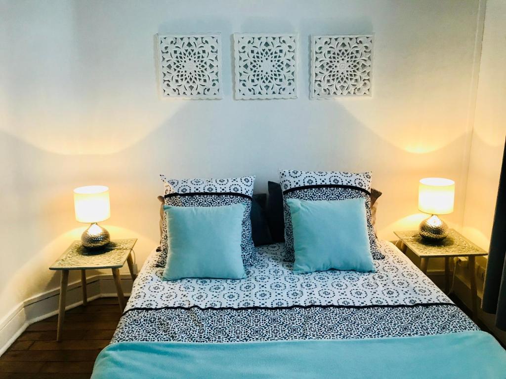 サン・マロにあるChambre d’hotes dans maison conviviale à St Maloのベッドルーム1室(青い枕とランプ2つ付)