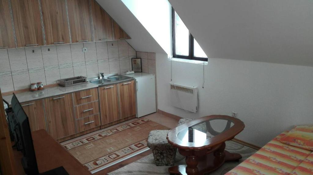 uma pequena cozinha com um lavatório e uma mesa em Apartment and rooms D&J em Žabljak
