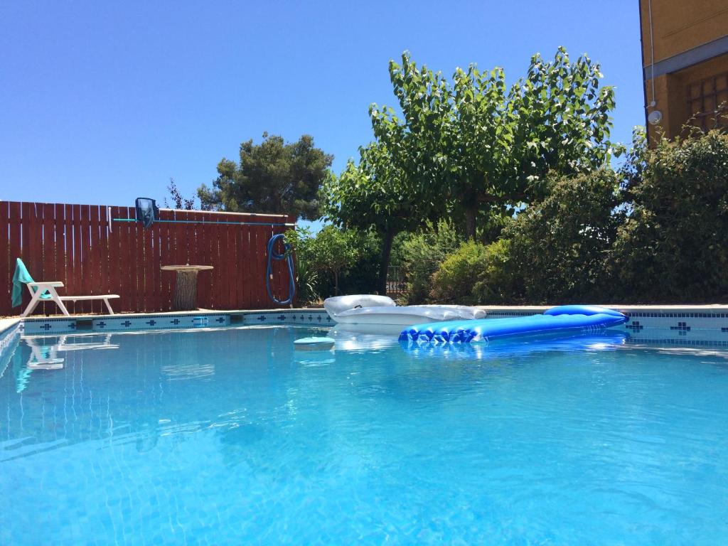 een groot zwembad met een blauw vlot erin bij Holiday Apartment with Pool in Tarragona