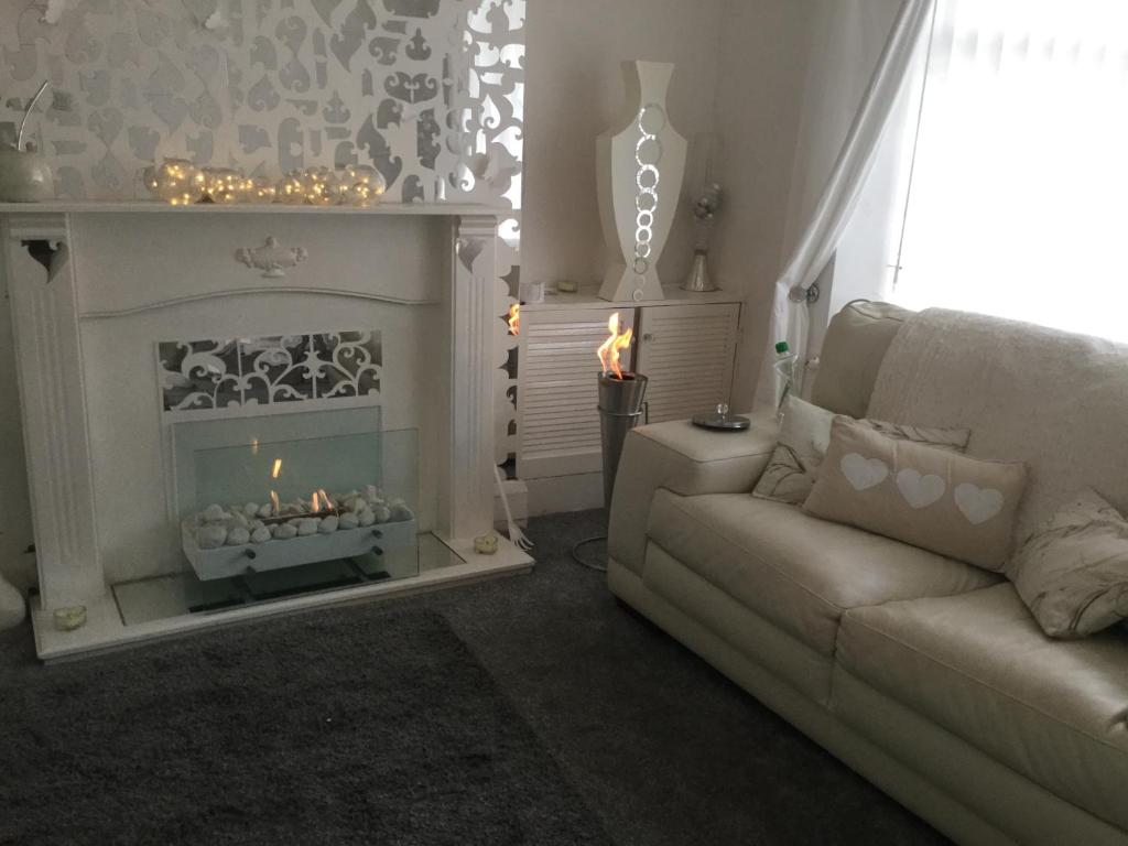 a living room with a couch and a fireplace at Anfield heart of Liverpool in Liverpool