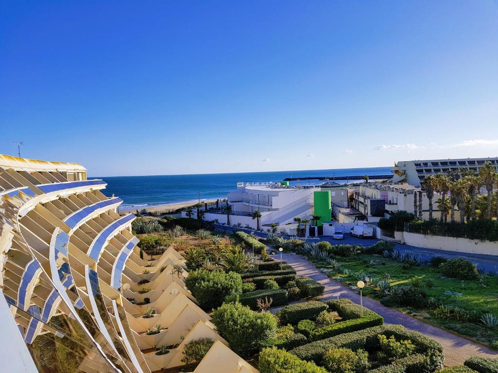 カップ・ダグドにあるCap d'Agde Naturist Apartmentsの海岸と海の景色を望む建物