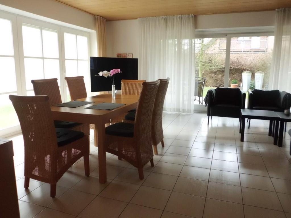 comedor con mesa de madera y sillas en Apartment am Vechtesee, en Schüttorf