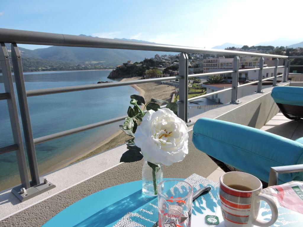 un jarrón con una flor sobre una mesa en un balcón en Plage Propriano 4 étoiles, en Propriano