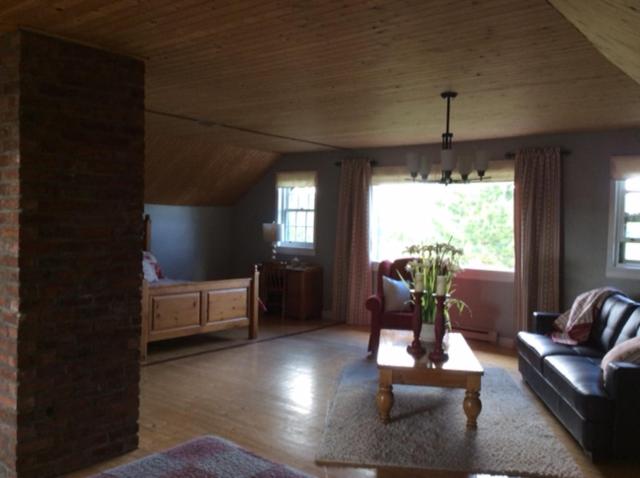 a living room with a couch and a table at La Maison Pamaljolie in Ayer's Cliff