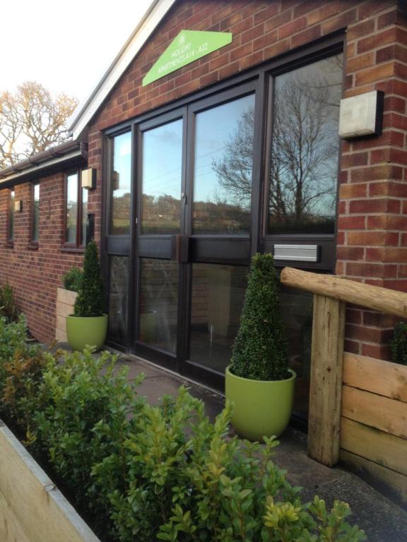 a building with large windows and plants in front of it at Newlands Holidays in Bridport
