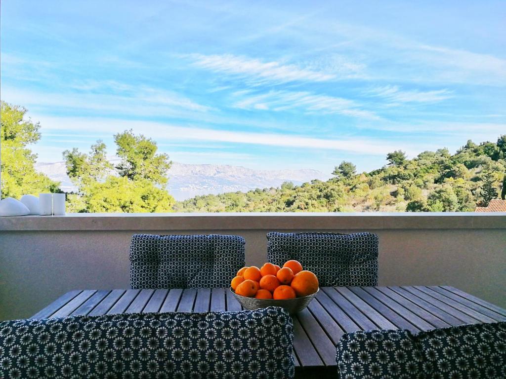 una ciotola di arance seduta su un tavolo sul balcone di Apartmani Marijana a Postira (Postire)