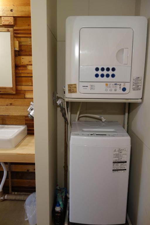 un forno a microonde in cima a un frigorifero in una cucina di Tomarotto Hostel a Takayama