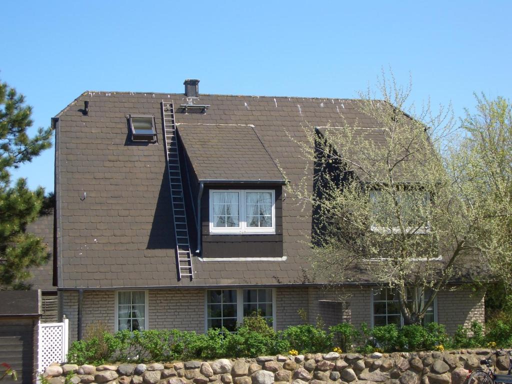 a house with a roof with a ladder on it at Sylter-Appartement in Wenningstedt