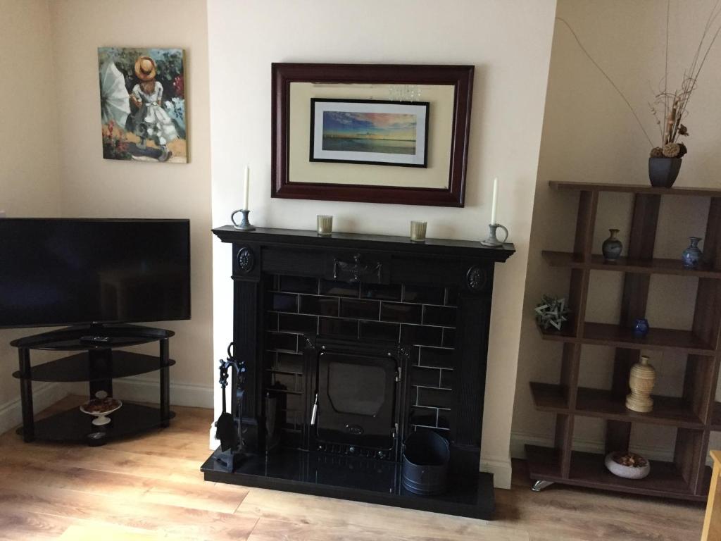 a living room with a fireplace and a television at Westport Holiday Home in Westport