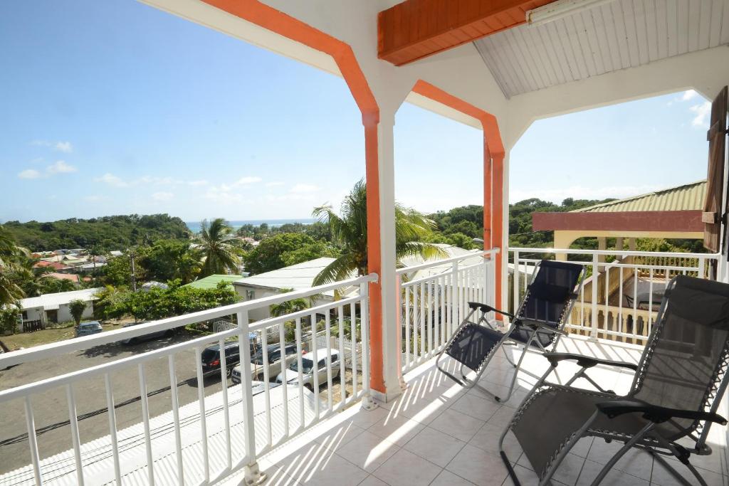 a balcony with chairs and a view of the ocean at Loca Vacances in Sainte-Anne