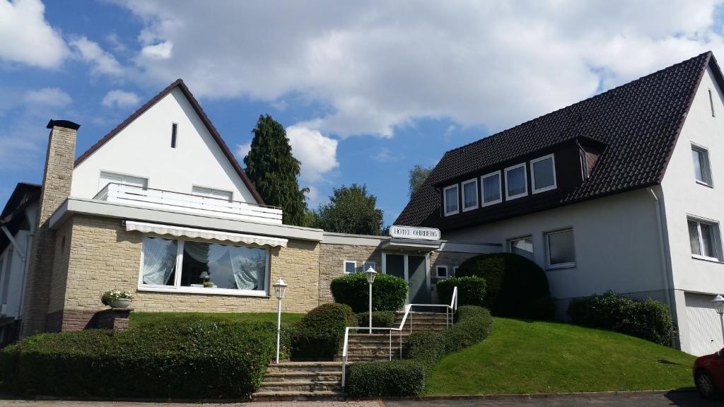 una casa blanca con techo negro en Hotel Ohrberg en Hameln