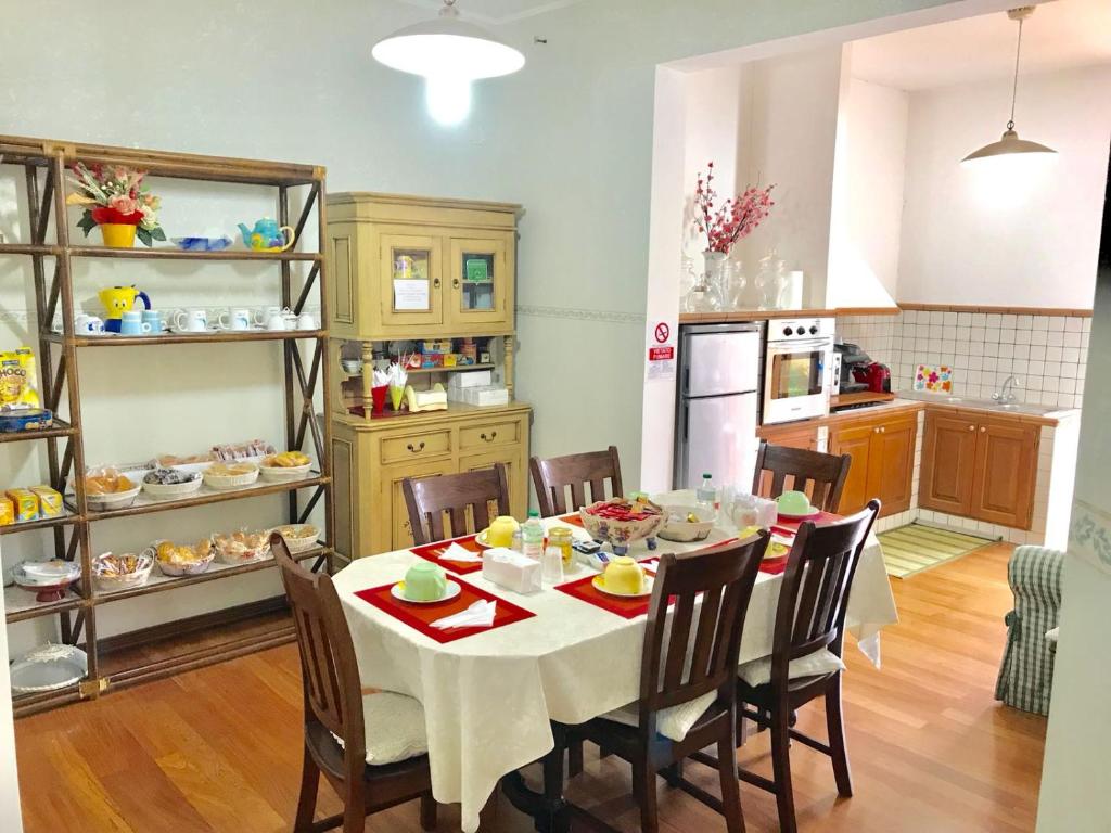 a dining room with a table and chairs and a kitchen at B&B La Vela 2 in Rieti