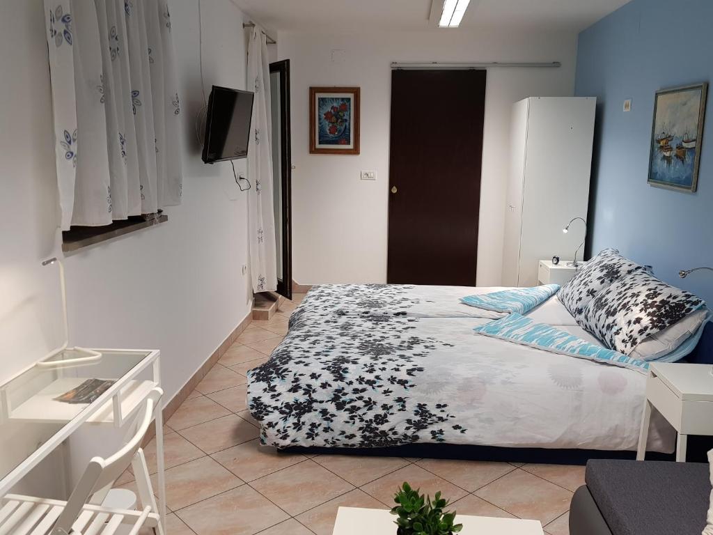 een slaapkamer met een bed en een tv. bij L&M room in Pula