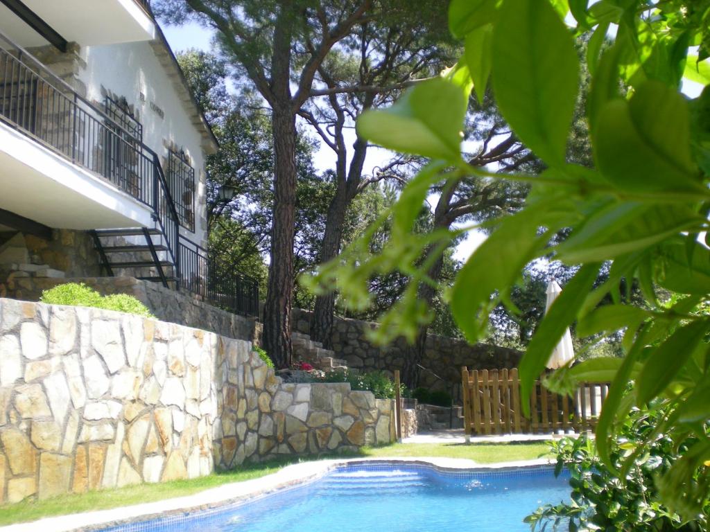 una piscina frente a una casa con una pared de piedra en Casa De Campo El Corzo, en Sotillo de la Adrada